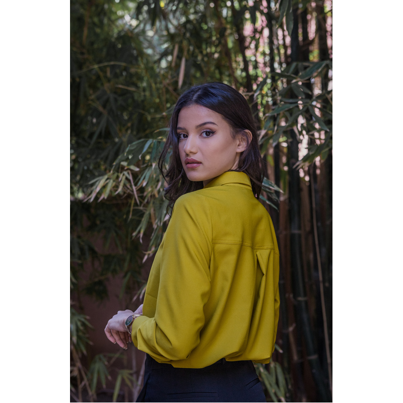 Chemise jaune foncé à volants pour une tenue chic et originale.