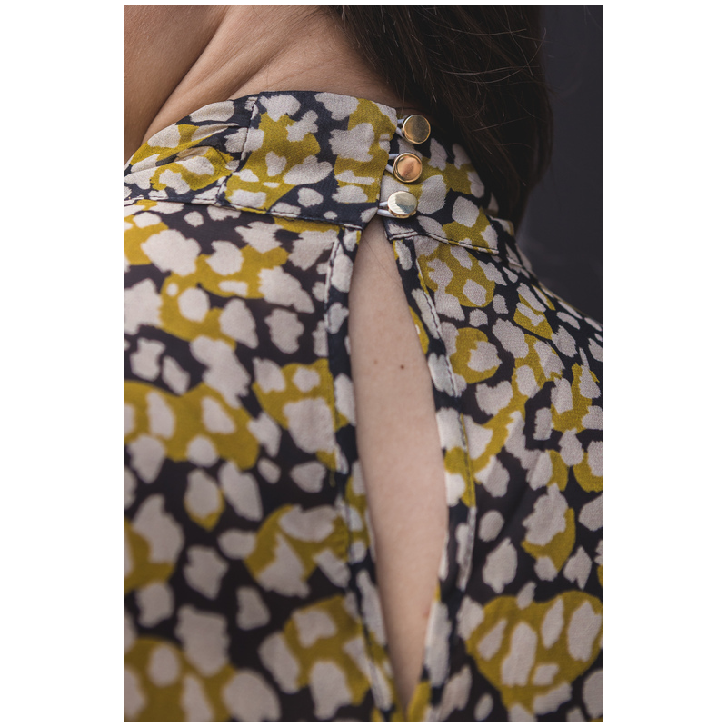 Blouse ornée en jaune, noir et blanc.