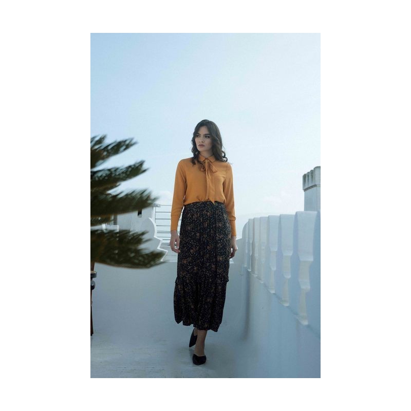 Jupe noire élégante et chemise jaune vibrante pour une tenue contrastée et stylée.