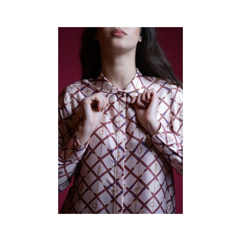 Détails de la chemise : Motifs blancs et marron sur fond coloré.