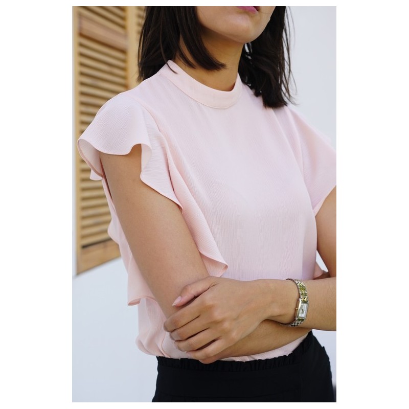 blouse rose clair à manches à volants.