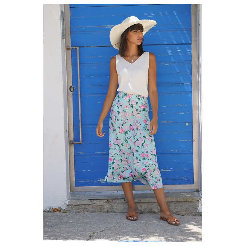 Top blanc assorti à une jupe aux couleurs vives pour une tenue estivale.