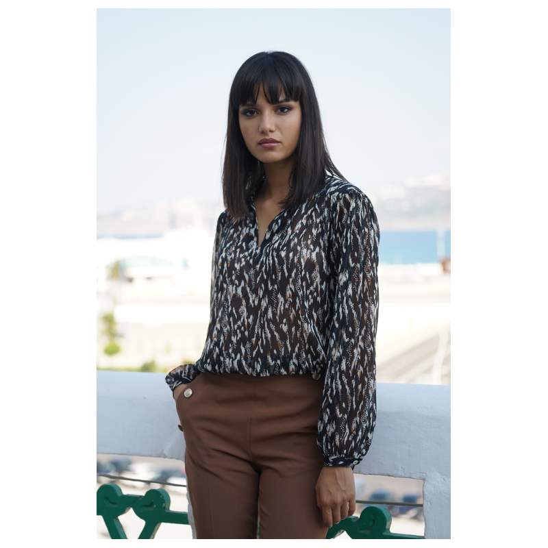 Détails de la blouse à carreaux noir et blanc : manches longues et col montant.
