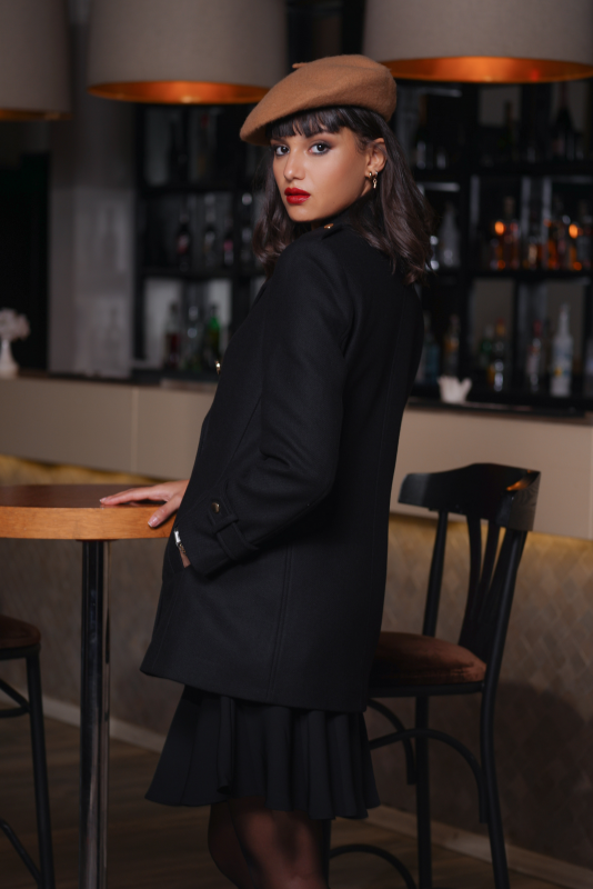 Un manteau noir avec des boutons traditionnels, un choix raffiné.