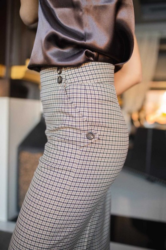 Détails du pantalon à carreaux marron et blanc, une harmonie de style.