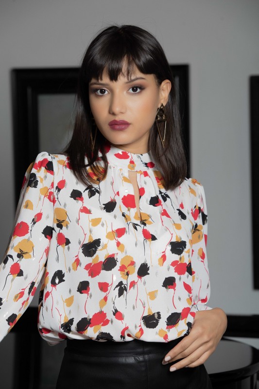 Blouse blanche décorée en noir et en rouge pour une touche d'originalité.