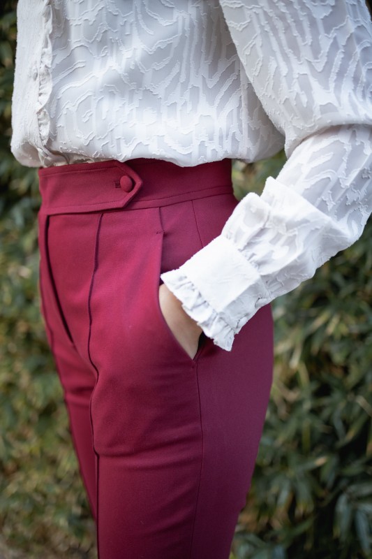 Détails du pantalon grenat classique, une pièce polyvalente.