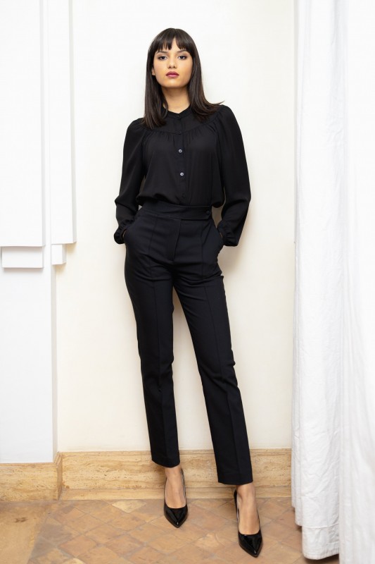 Blouse noire élégante pour un look chic et sobre.