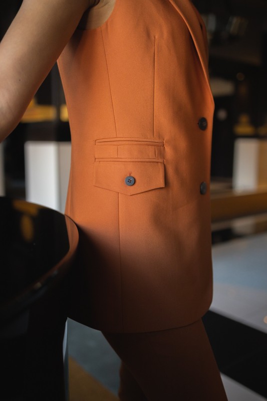 Détails du gilet : Couleur orange et style audacieux.