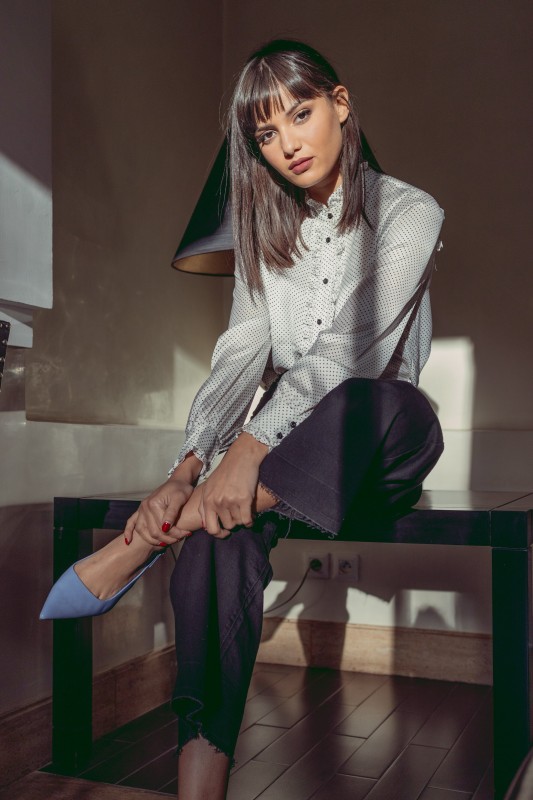 Blouse blanche à pois noirs pour un style rétro.