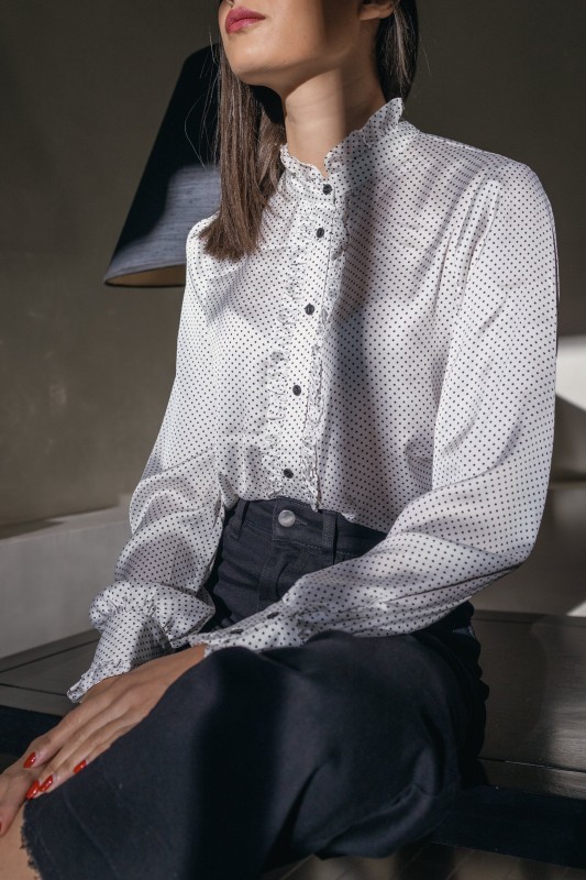 Détails de la blouse : Motif à pois noirs et manches courtes.