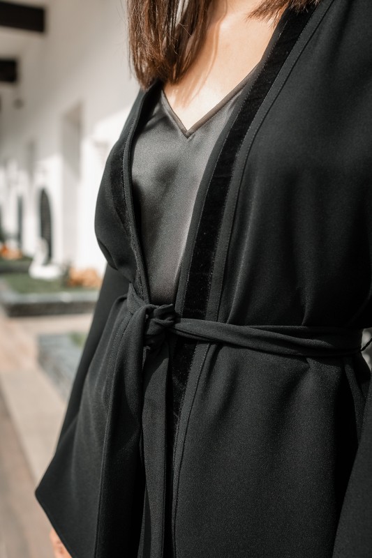 Détails d'un kimono noir avec une ceinture noire, une élégance sobre.