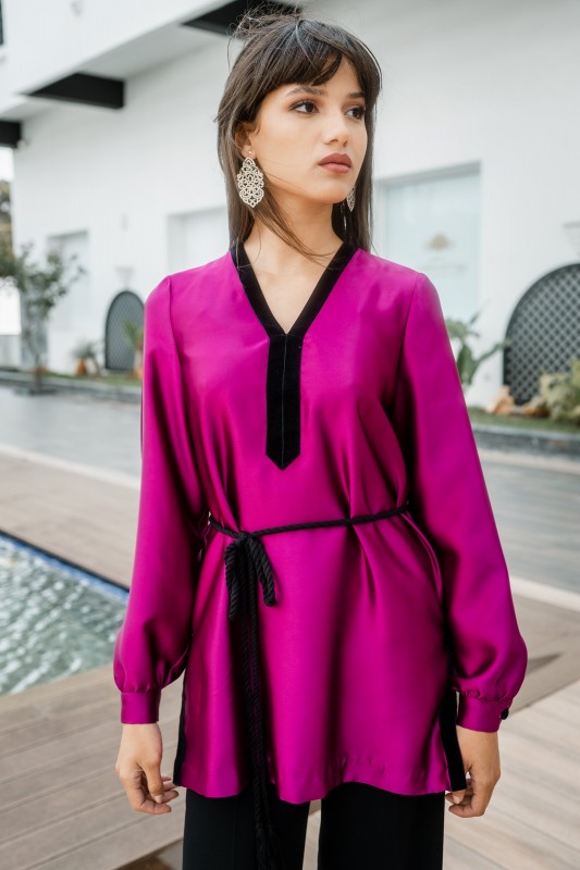 Détails de la blouse rose foncé : manches courtes et tissu fluide.