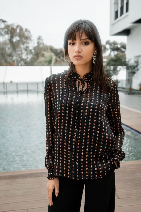 Blouse noire élégante avec des motifs.