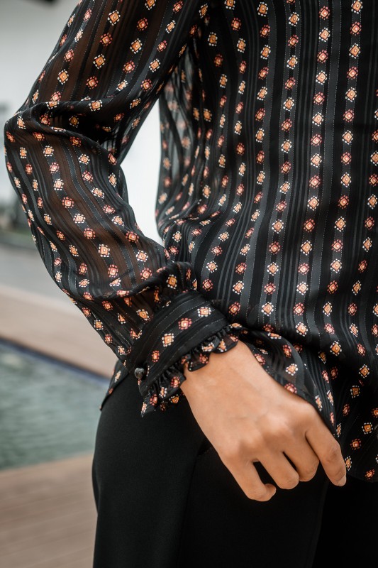 Détails de la Blouse noire élégante avec des motifs.