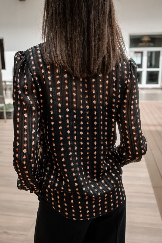 Le dos de la Blouse noire élégante avec des motifs.