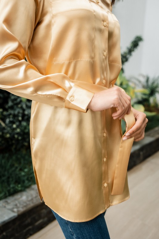 Détails de la chemise : Couleur or et style luxueux.