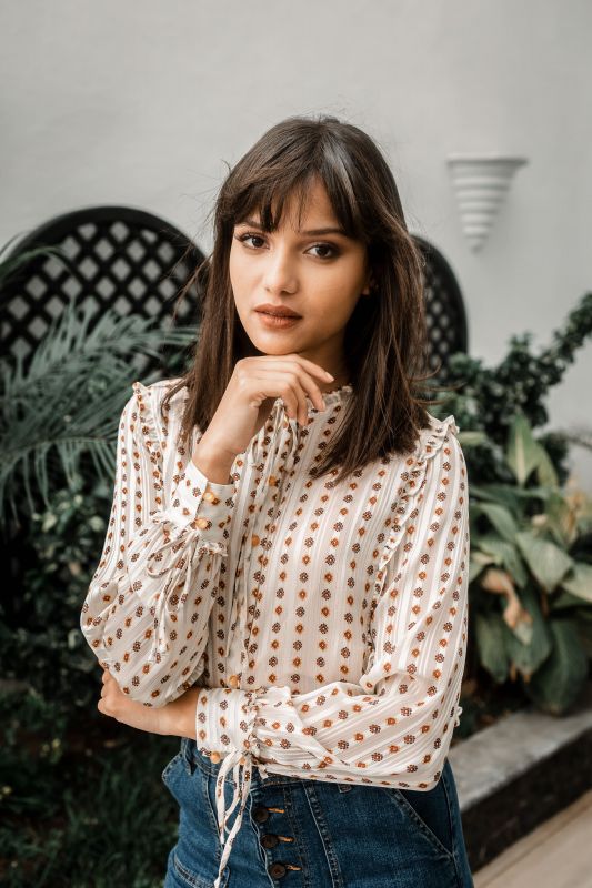 Découvrez cette chemise blanche aux détails dorés pour un look sophistiqué.