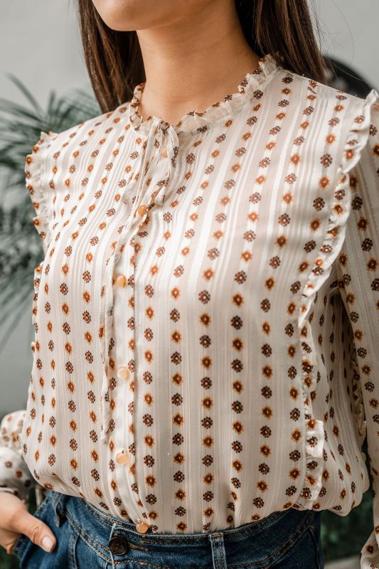 Explorez les finitions dorées de cette chemise blanche pour une tenue unique.