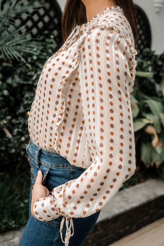 Explorez les finitions dorées de cette chemise blanche pour une tenue unique.