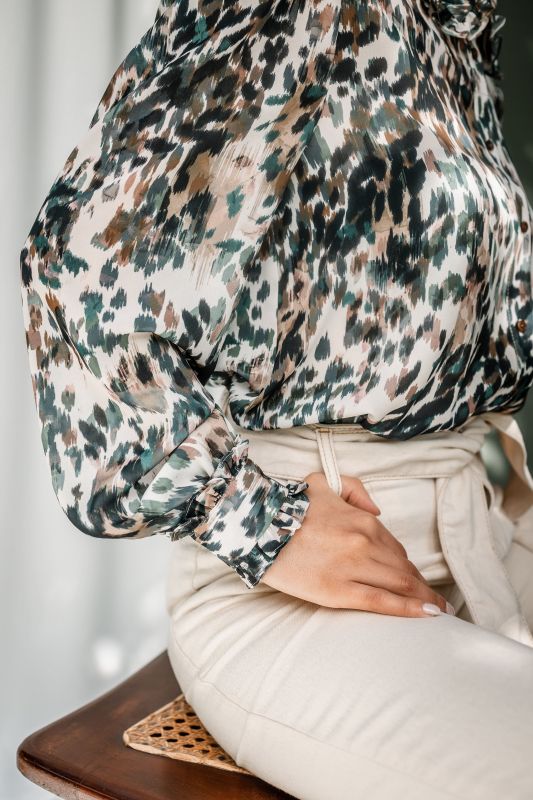 Détails de la chemise : Motifs verts et rayures sur un fond blanc cassé.
