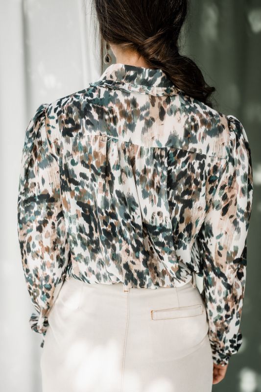 Détails de la chemise : Motifs verts et rayures sur un fond blanc cassé.