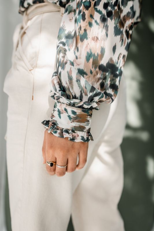 Détails de la chemise : Motifs verts et rayures sur un fond blanc cassé.