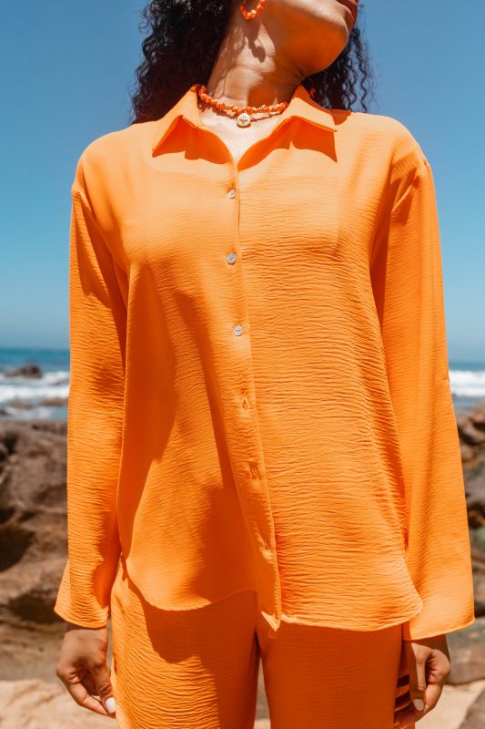 Détails uniques sur cette CHEMISE orange.