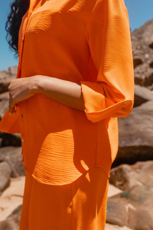 Détails uniques sur cette CHEMISE orange.