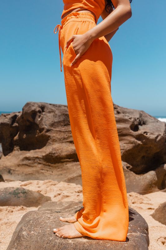 Détails en gros plan du pantalon long orange pour femmes.