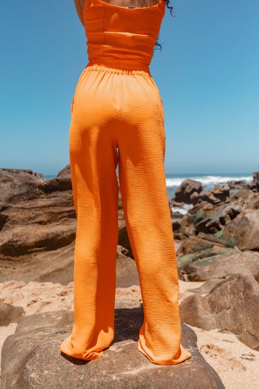 Détails en gros plan du pantalon long orange pour femmes.