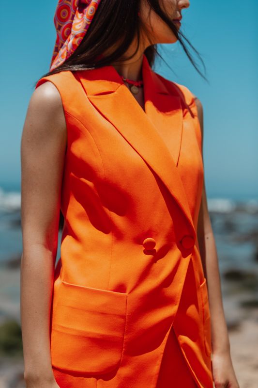 Détails du gilet : Couleur orange et style audacieux.