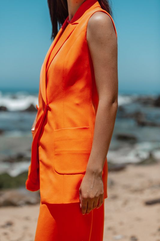 Détails du gilet : Couleur orange et style audacieux.
