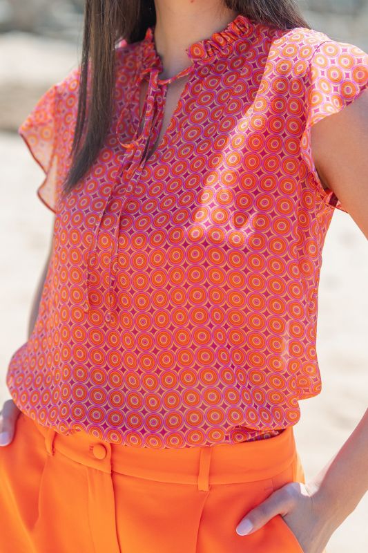 Blouse corail parsemée de pois noirs : Une touche de couleur et d'élégance.