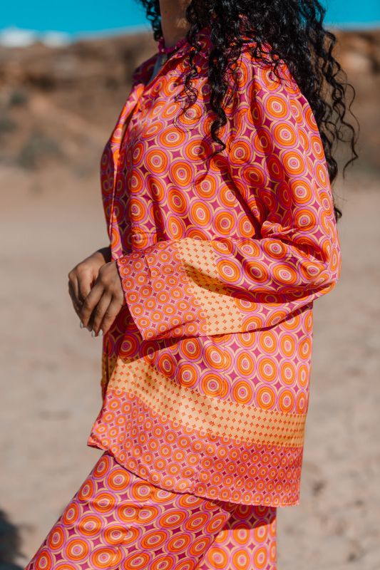 Détails de la chemise : Motifs de cercles et couleur orange.