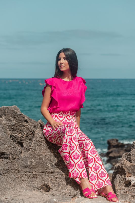Pantalon rose avec ornement sur fond blanc, pour un look raffiné.