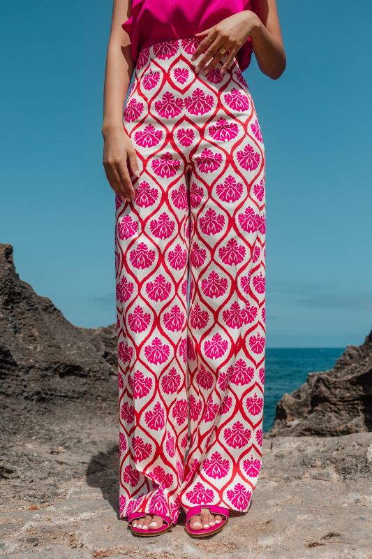 Pantalon rose avec ornement sur fond blanc, pour un look raffiné.