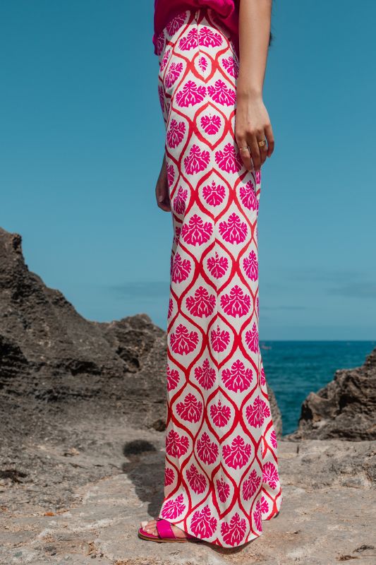 Un élégant pantalon rose orné, pour une tenue remarquable sur fond blanc.