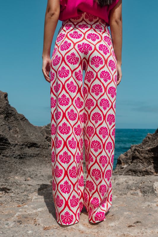 Détails du pantalon rose orné avec fond blanc, une option chic.