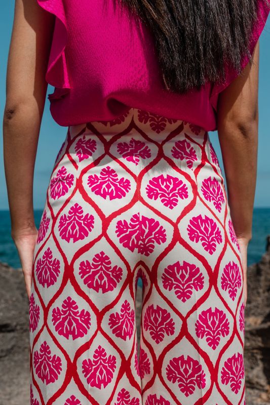 Détails du pantalon rose orné avec fond blanc, une option chic.