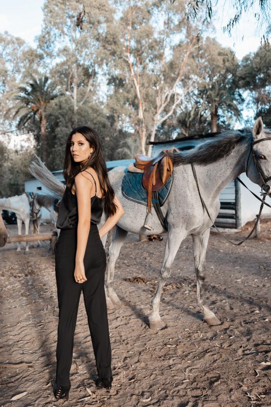Pantalon rose orné, élégance contrastée sur fond blanc.