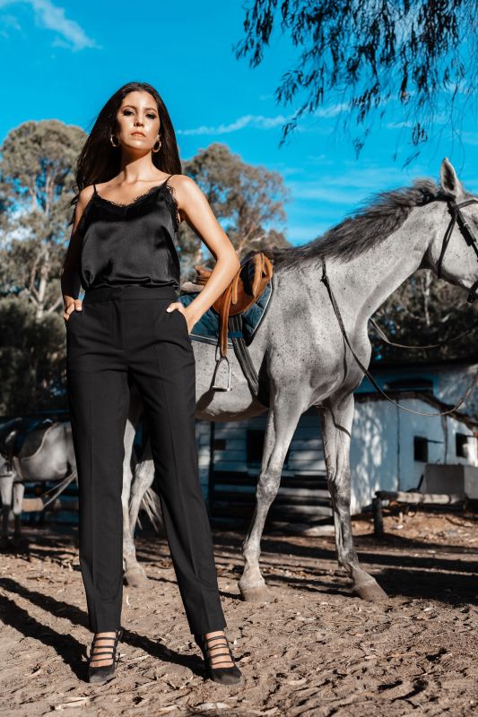 Un élégant pantalon rose orné, pour une tenue remarquable sur fond blanc.