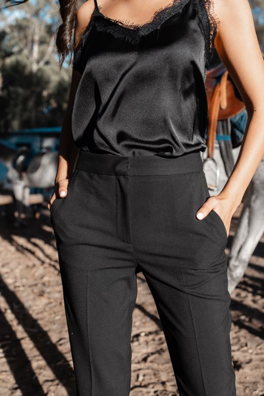 Détails du pantalon rose orné avec fond blanc, une option chic.