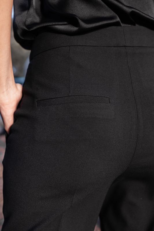 Détails du pantalon rose orné avec fond blanc, une option chic.