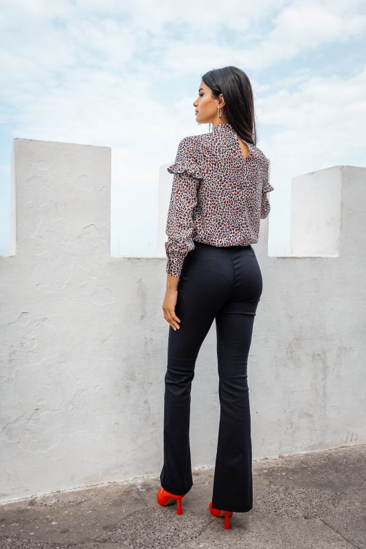 Blouse pour femme ornée de détails raffinés sur un fond neutre.