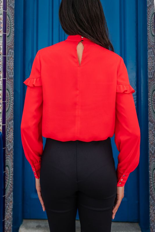 Détails de la blouse rouge pour femme, révélant sa teinte profonde et ses finitions soignées.