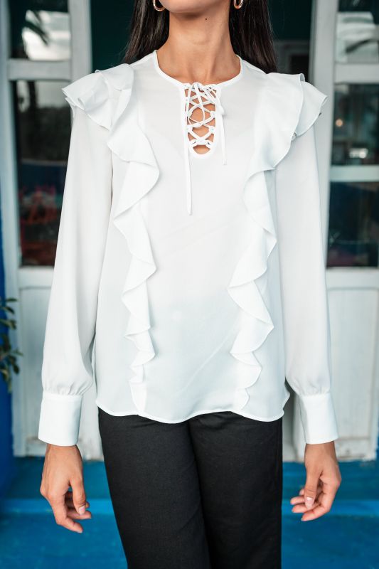 Blouse blanche pure pour femme sur un fond neutre.