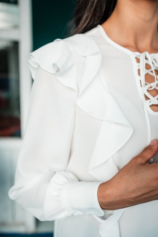 Détails de la blouse blanche pour femme, mettant en lumière sa texture douce et ses finitions délicates.