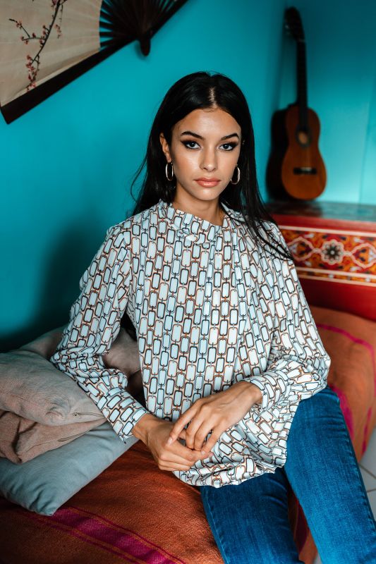 Blouse blanche ornée de motifs vibrants pour une tenue dynamique.