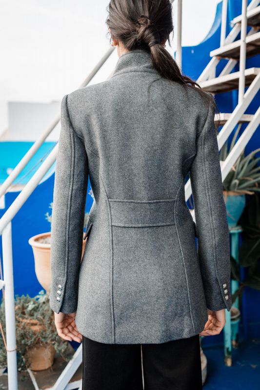 Détails de la doublure boutonnée d'un manteau gris.